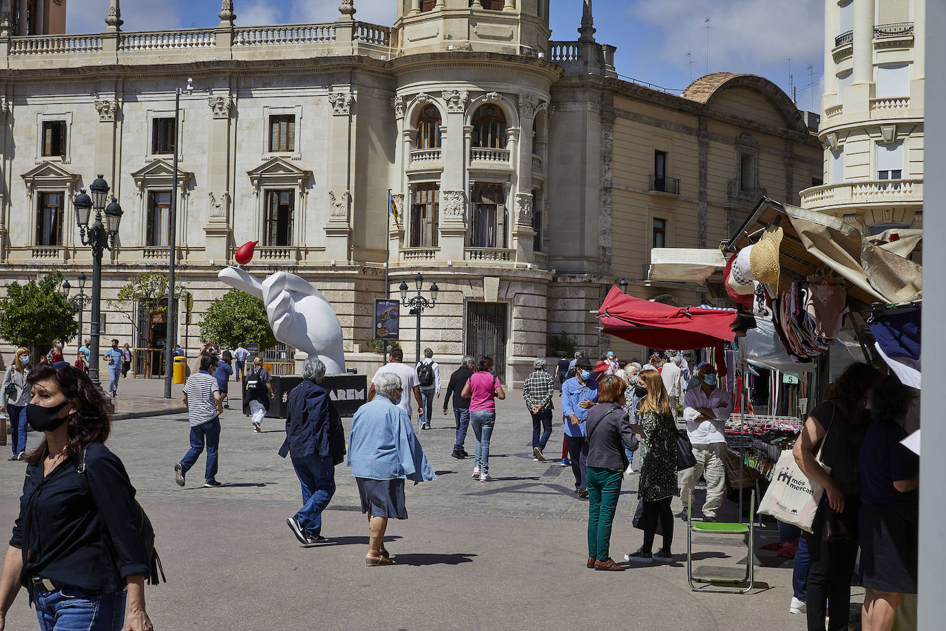 Protestas, mercadillos y restos de instalaciones se mezclan junto a la plaza del Ayuntamiento. Comerciantes y vecinos de la zona insisten en los problemas para acceder en coche mientras el monolito del 15M sigue protegido por vallas.