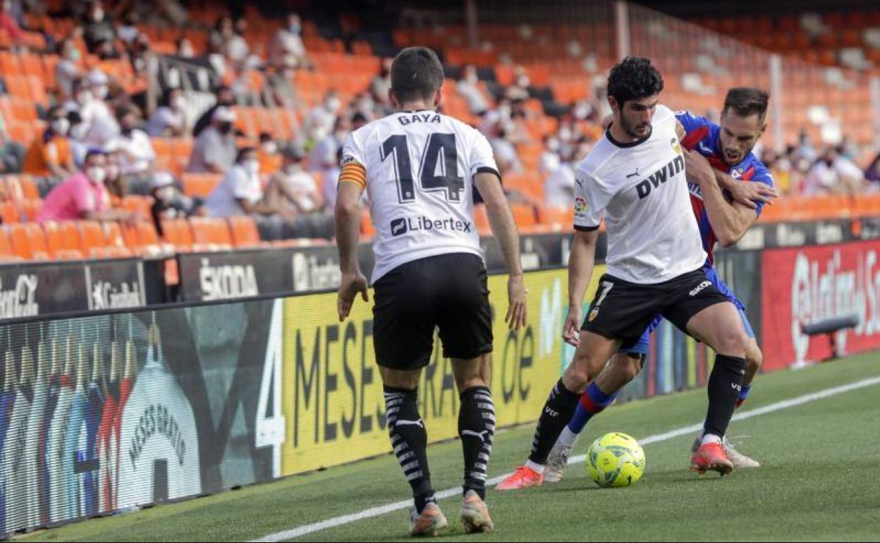 Guedes protege el balón ante la mirada de Gayà durante el partido contra el Eibar. 