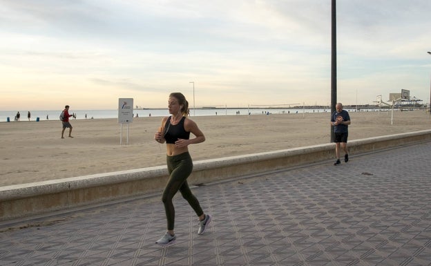 Una mujer practica deporte en el paseo de la Malvarrosa de Valencia a última hora del día. 