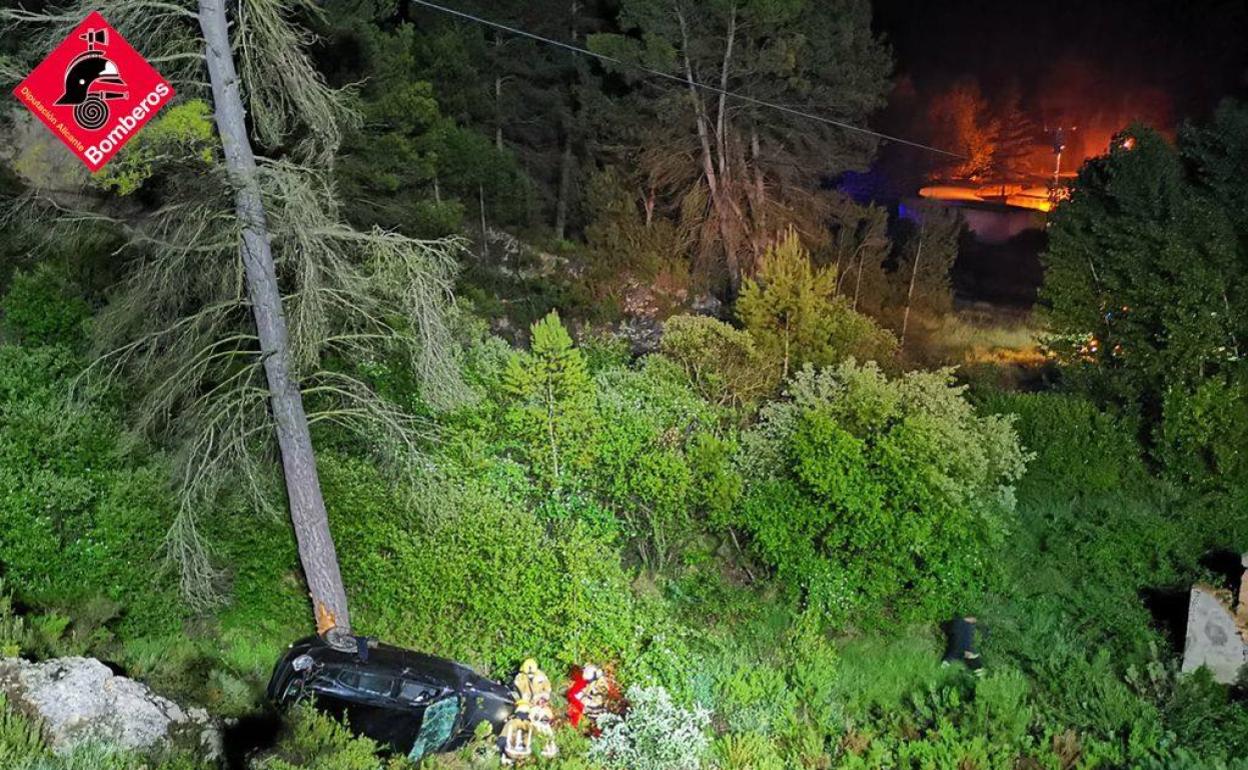 El vehículo volcado en el barranco durante su rescate por los bomberos. 