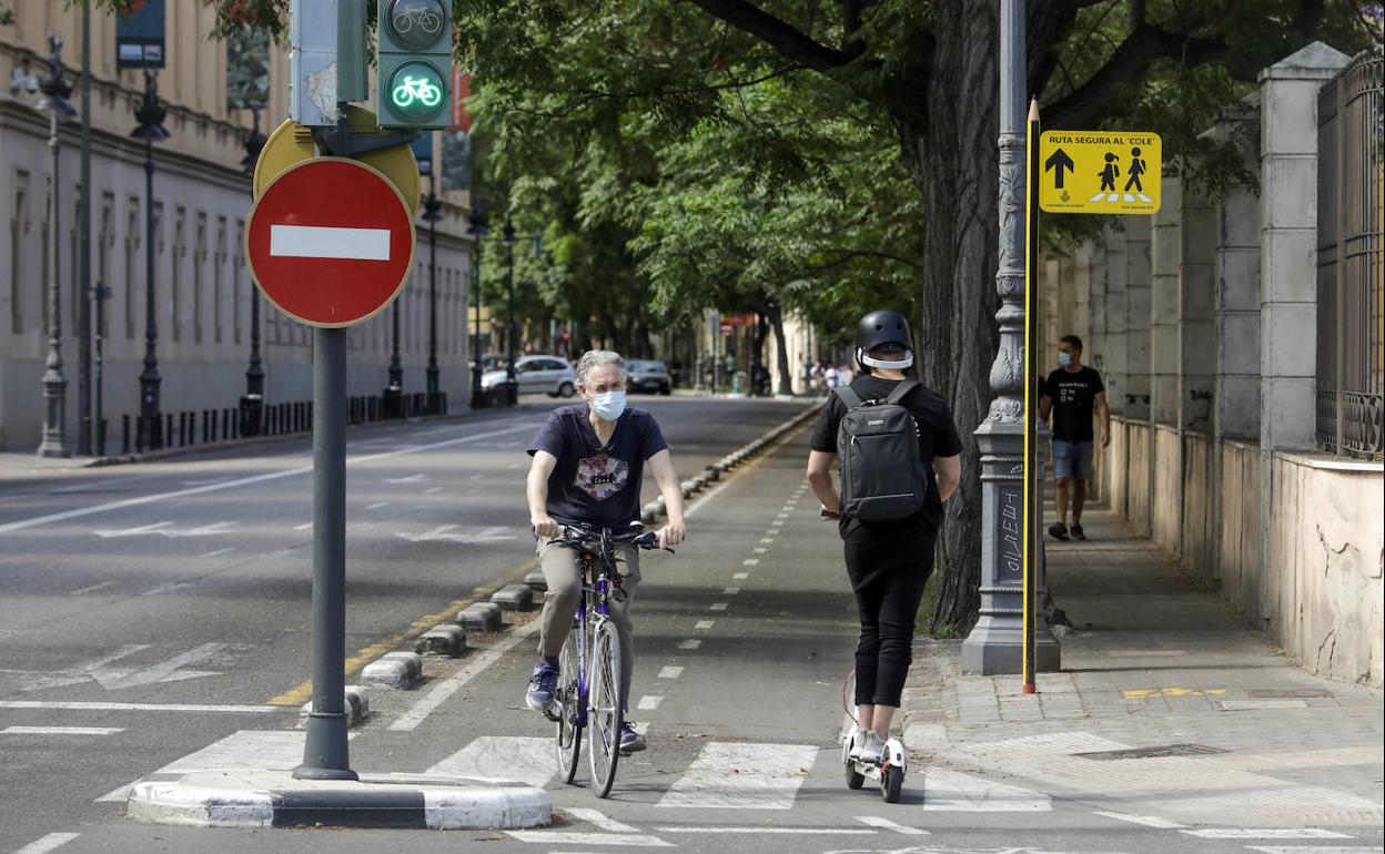 Un ciclista y una usuaria de patinete circulan, ayer por la mañana, por una calle del centro de Valencia. 