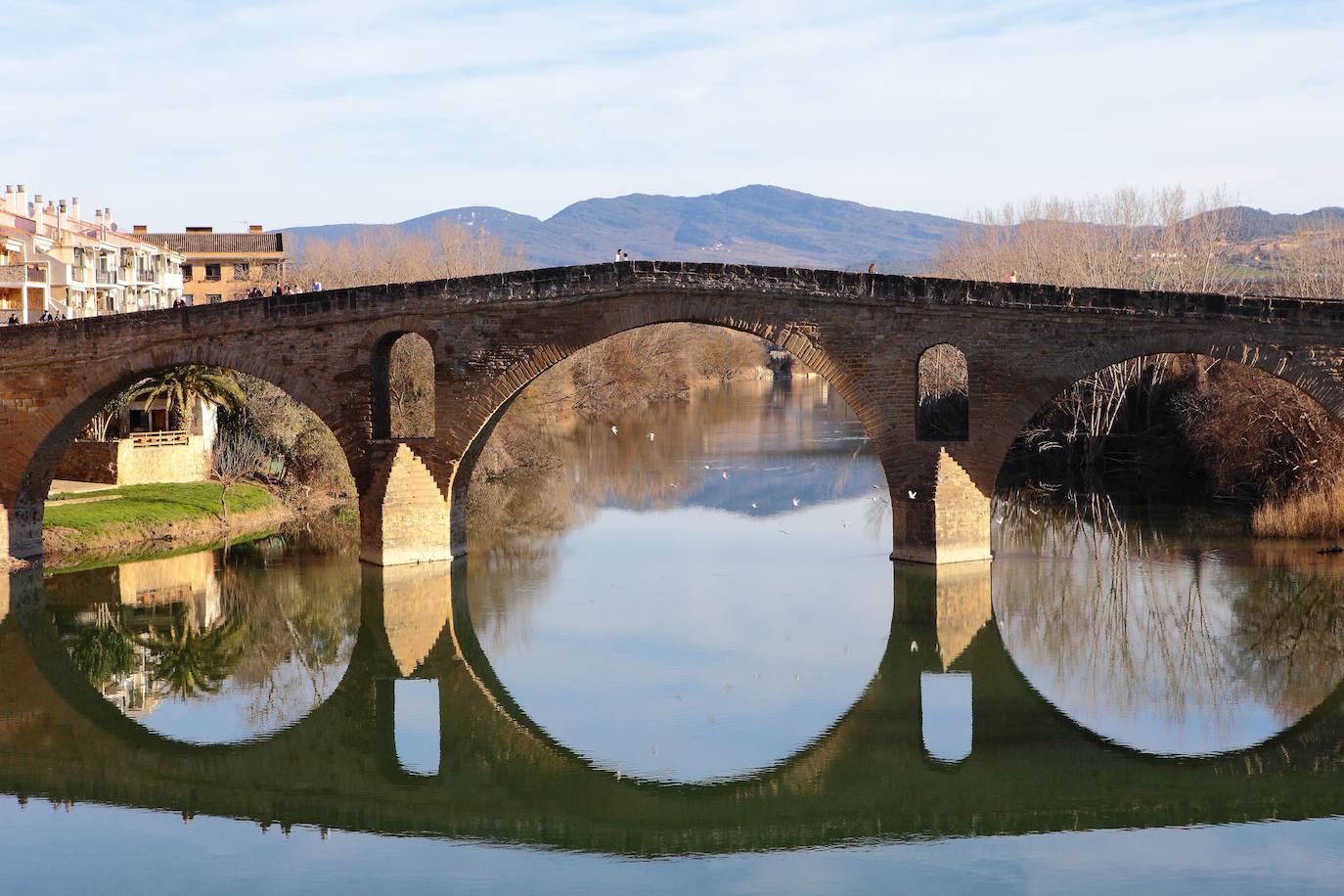 14.- Puente de la Reina (Navarra) | El puente románico sobre el río Arga -en la imagen- fue construido en el siglo XI y ayuda a los peregrinos a continuar con su camino. Esta villa se encuentra a sólo 24 kilómetros de Pamplona y es un punto importante en el Camino de Santiago por juntarse en ella los dos caminos que vienen desde Francia, la ruta desde Orreaga/Roncesvalles y la de Somport. 