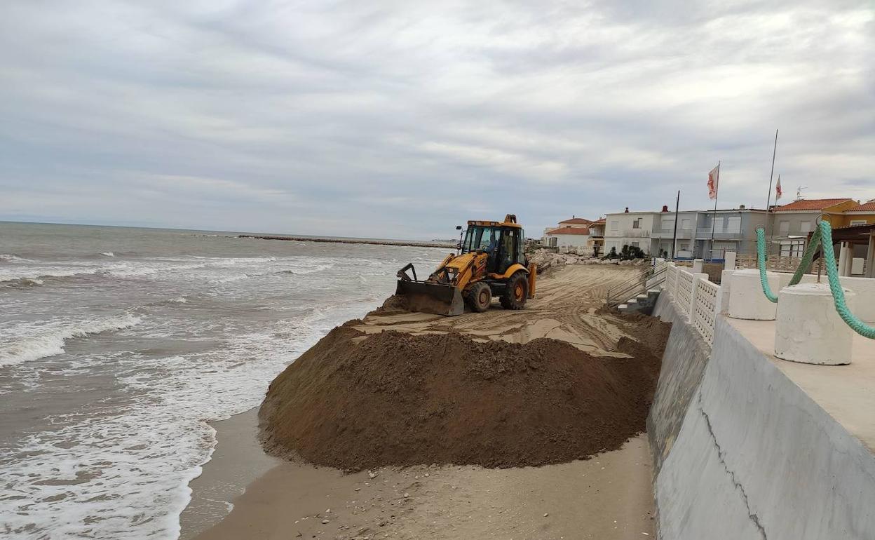 Una máquina trabaja aportando arena en la playa de Les Deveses. 