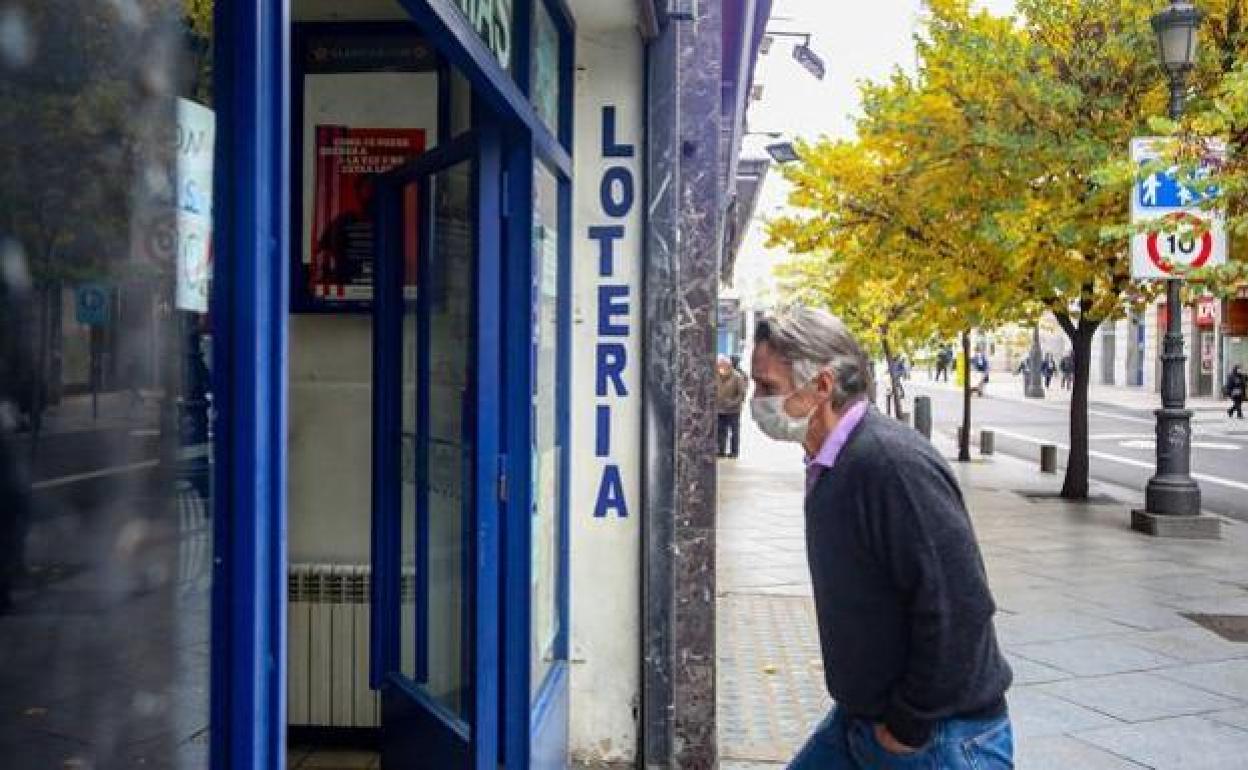 Un hombre entra a una administración de Loterías y Apuestas del Estado.