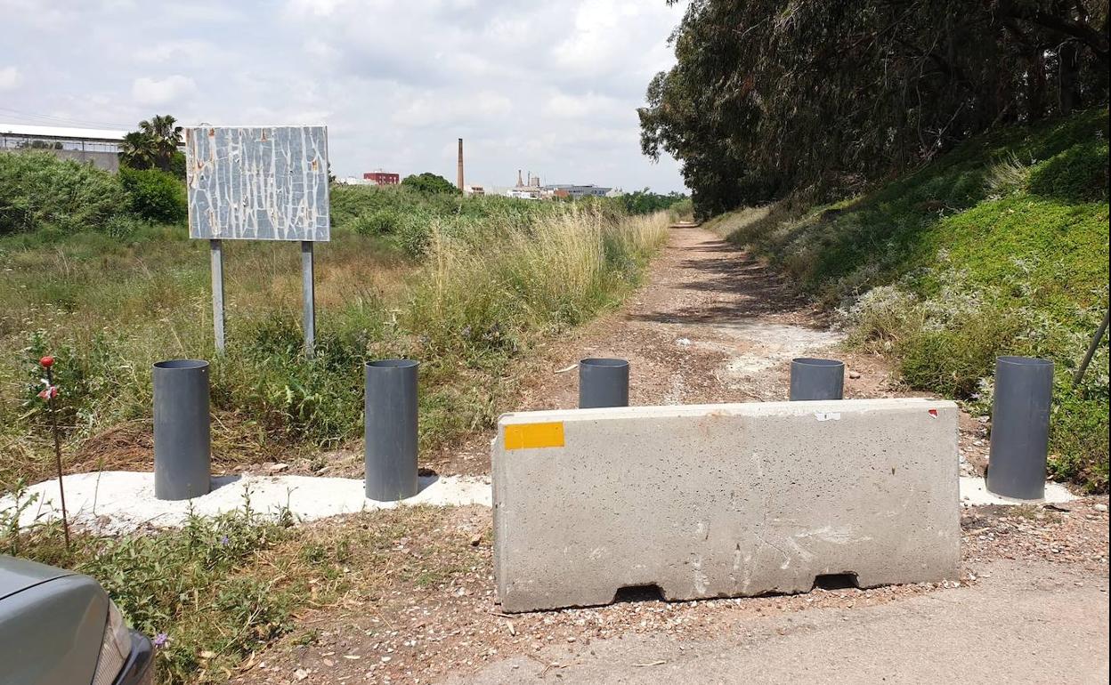 Un bloque de cemento y pivotes colocados en el acceso al barranco en Foios. 