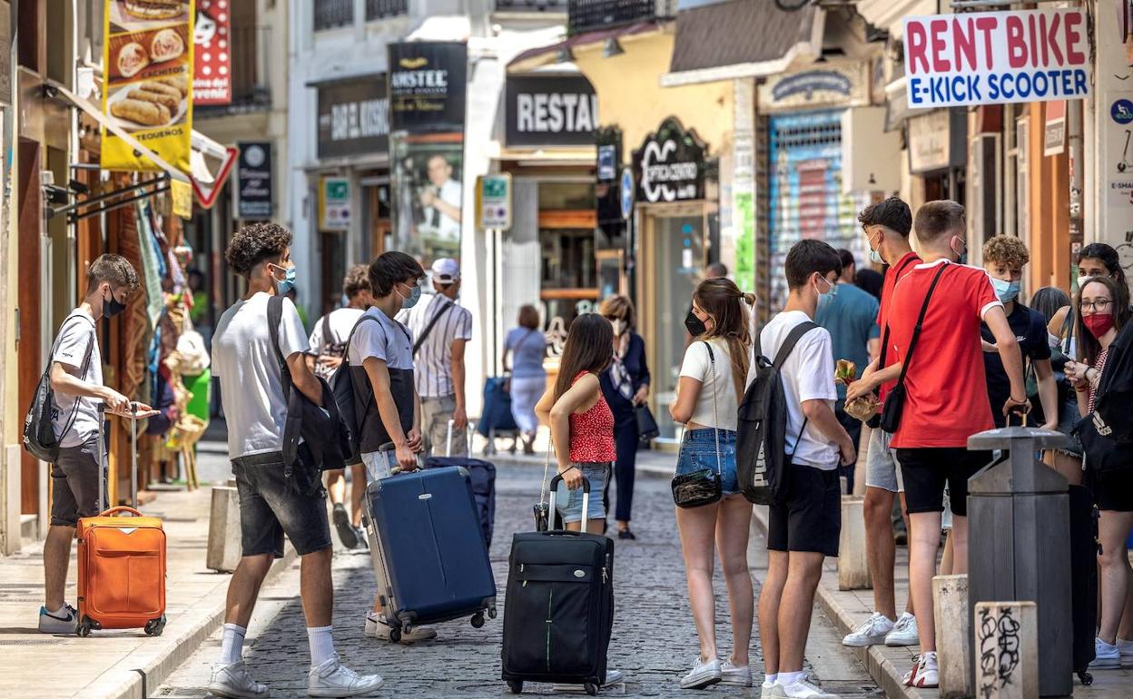 Varios jóvenes con maletas en Valencia. 