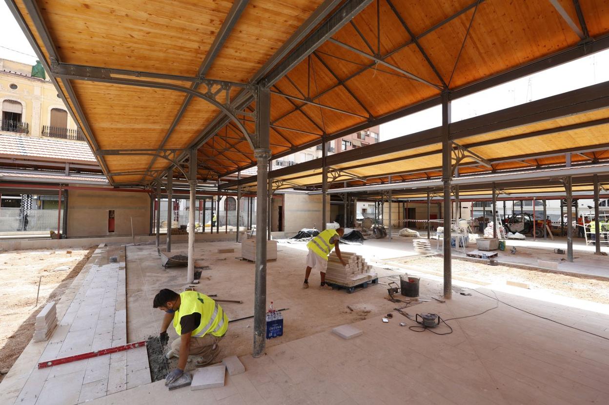 Operarios trabajando en el pavimento del nuevo mercado, ayer. jesús signes