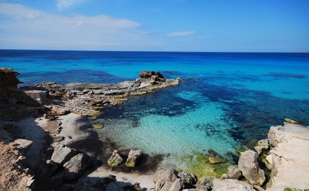 Imagen principal - En la foto superior, el Caló des Morts, situado en la isla de Formentera. Abajo a la izquierda, la playa Rodas, perteneciente a las Islas Cíes. Abajo a la derecha, niños observan a personas hacer kitesurfing. 