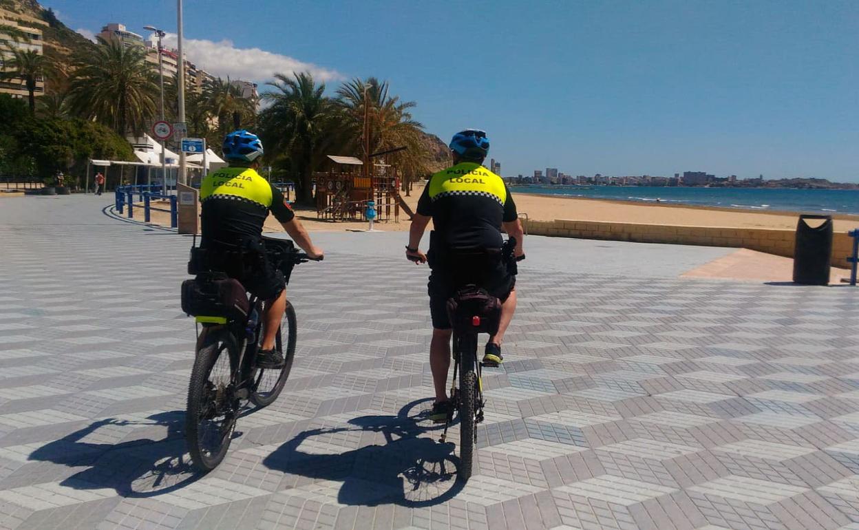 Dos agentes vigilan la playa de El Postiguet en Alicante. 