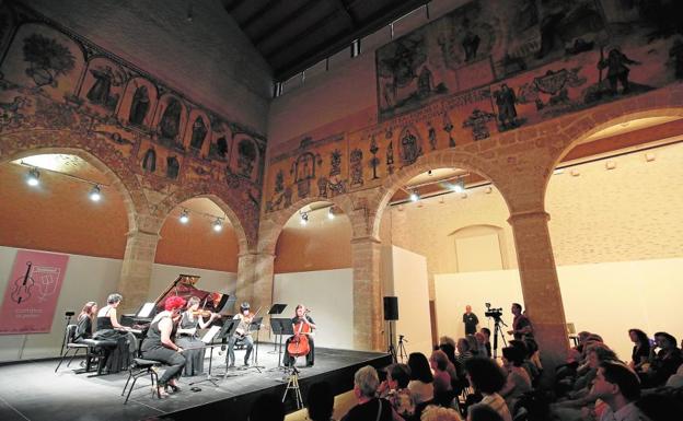 Celebración de un concierto en el Almudín, con los frescos en la parte superior.