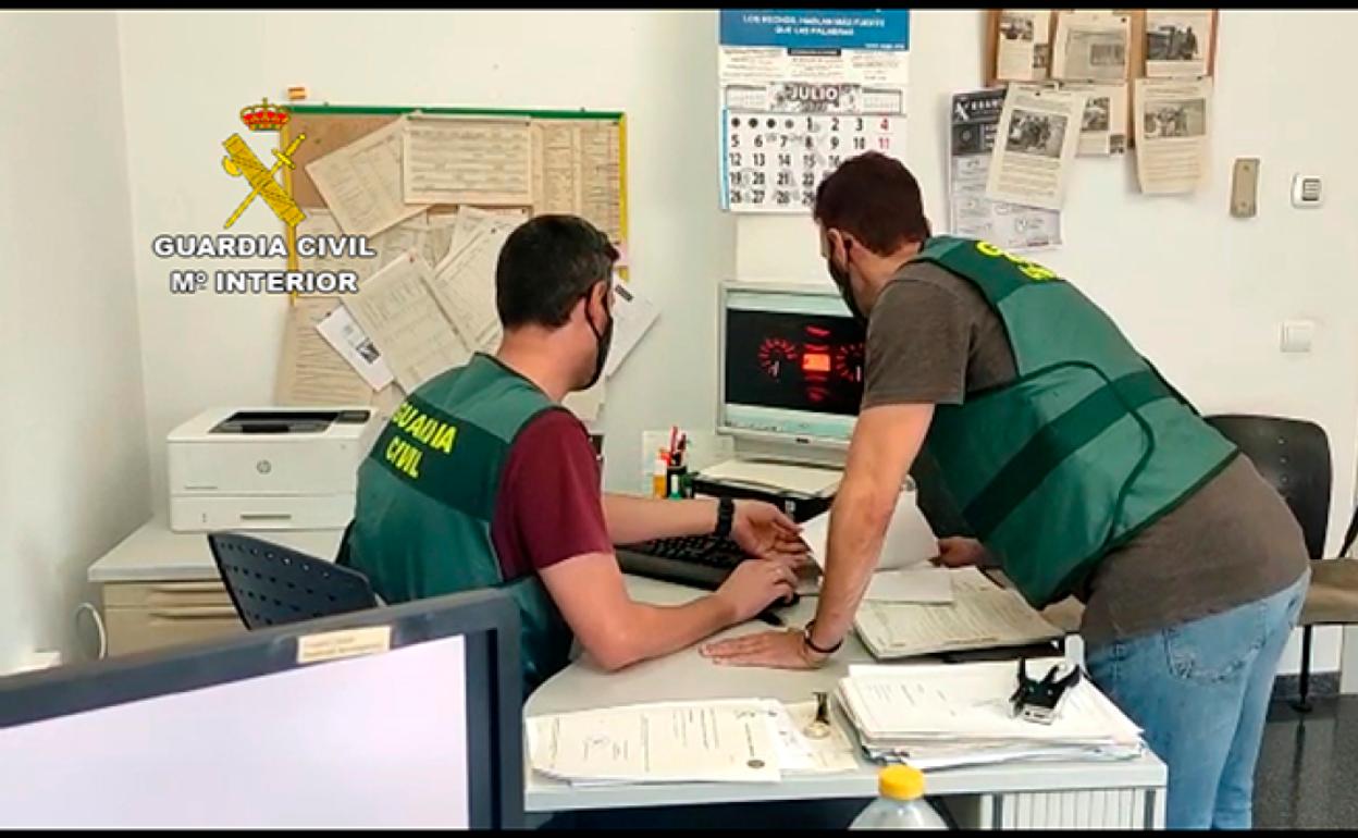 Dos agentes comprueban documentación sobre las motocicletas. 