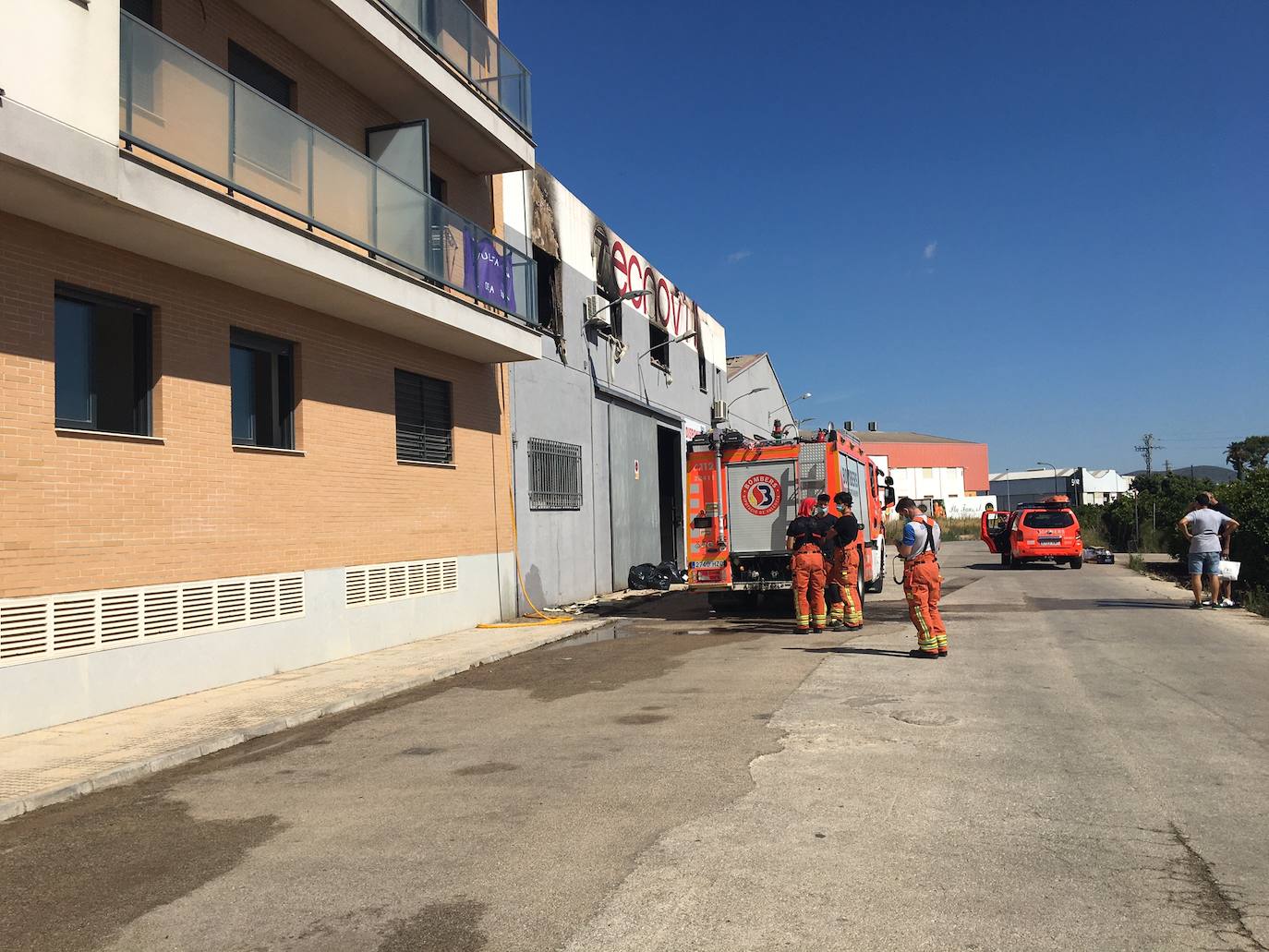 El incendio que ha arrasado un almacén de muebles en Beniarjó ha dañado, además, cuatro viviendas y un piso, todos recayentes a la calle Sant Enric de la población de la Safor.