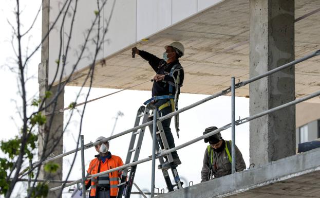 Tres trabajdores en una obra. 