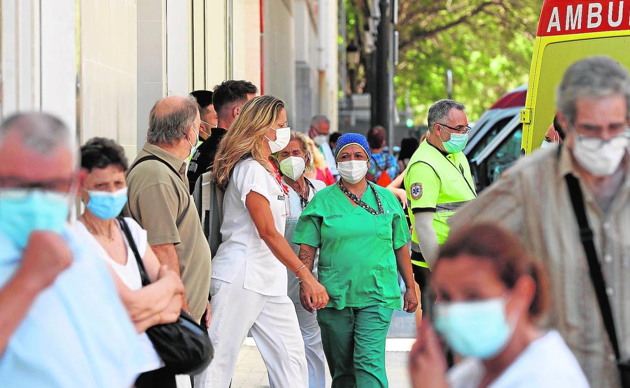 Personal sanitario y pacientes a las puertas del servicio de Urgencias del hospital Clínico de Valencia, ayer.