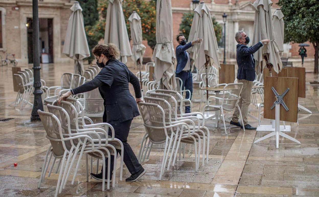 Unos camareros preparan la terraza de un bar en Valencia. 