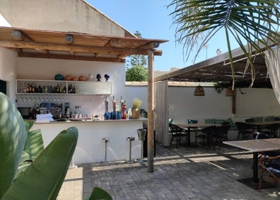 Imagen secundaria 1 - Arriba, la terraza exterior del restaurante La Chipirona Playa. Abajo a la izquierda, barra del patio interior. Abajo a la derecha, mesas de la terraza interior.