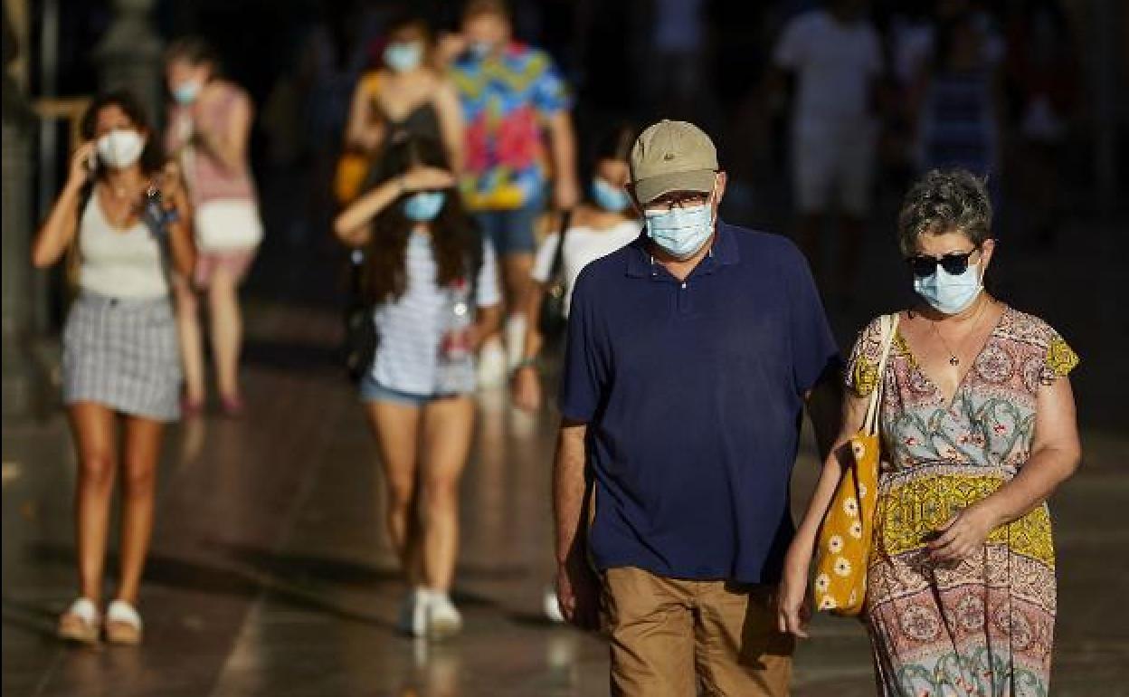 Varias personas con mascarilla en el centro de Valencia.