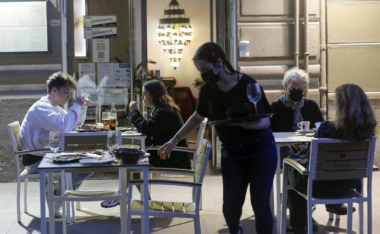 Grupos de personas tomando algo en una terraza. 