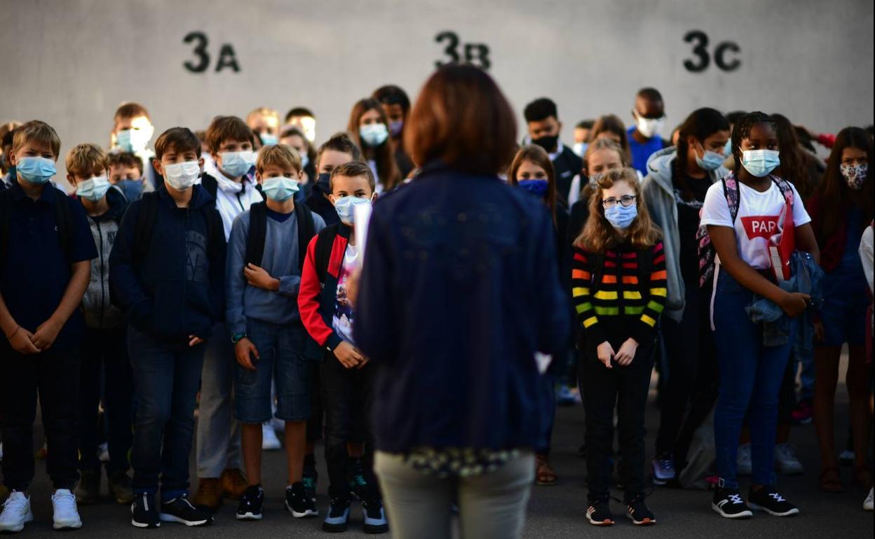 Alumnos franceses con mascarillas escuchan a una docente de una escuela secundaria en Vicennes en el arranque del pasado curso escolar.