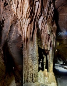 Imagen secundaria 2 - Arriba, una de las salas de las cuevas. Abajo a la izquierda, un barquero guía a los visitantes a través de las grutas. Abajo a la derecha, una columna de las cuevas. 