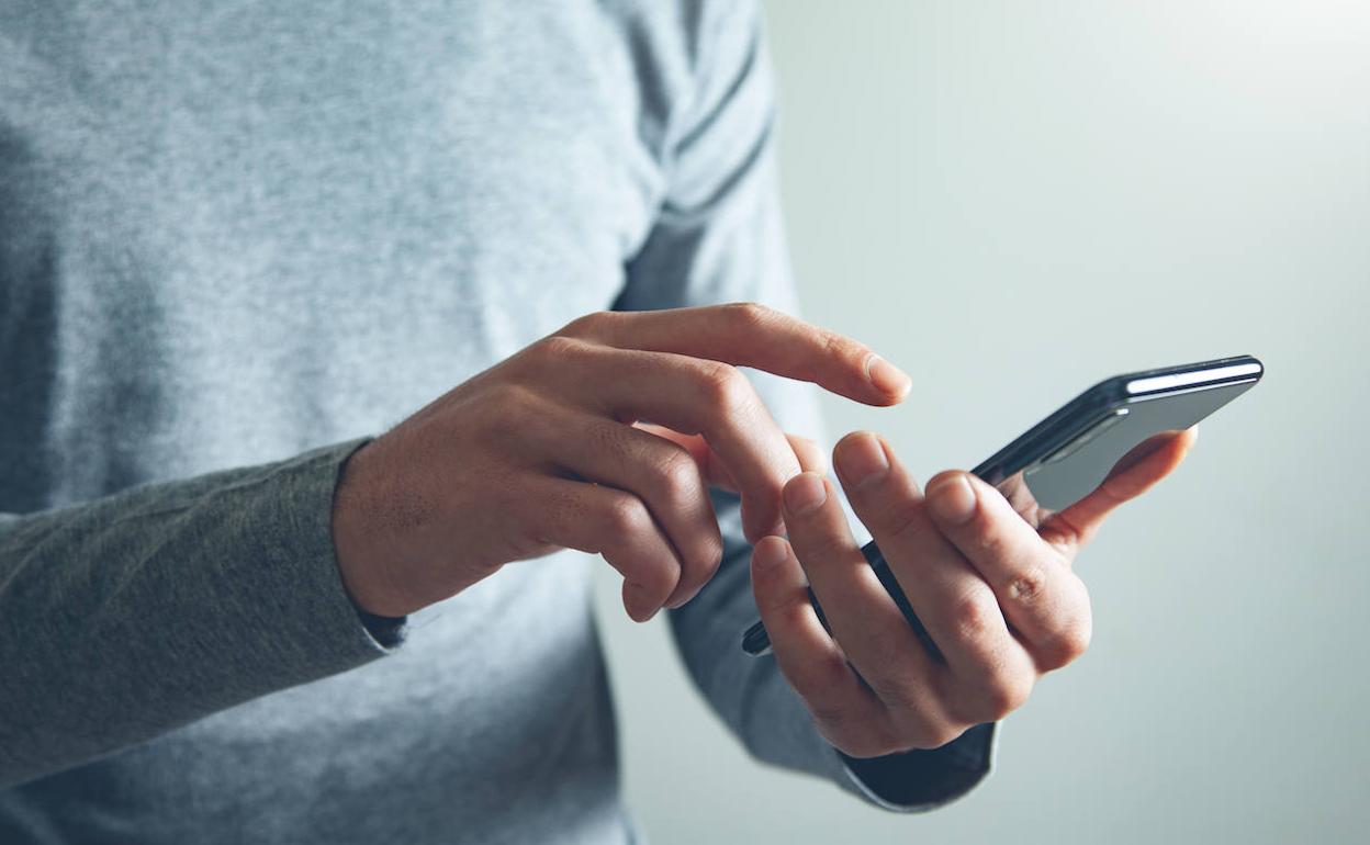 Un hombre utiliza un teléfono móvil.