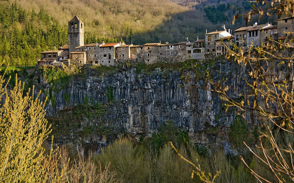 CASTELLFOLLIT DE LA ROCA (GIRONA, CATALUÑA) | Perteneciente al partido judicial de Olot, Castellfollit de la Roca es uno de los términos más pequeños de España, con menos de 1 kilómetro cuadrado de superficie. Este pueblo, de gran belleza y enclave único, se sostiene sobre un riscal basáltico de 50 metros de altura y de casi un kilómetro de largura, rodeado por el río Fluviá. Sus casas flotantes situadas al borde del abismo y la antigua iglesia de Sant Salvador, situada justo en uno de sus extremos, convierten a este pueblo en una visita más que recomendada.