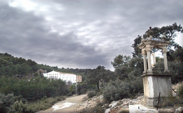 Imagen principal - Arriba, a mano derecha, una de las estaciones de la romería hasta la Cueva Santa. Abajo a la izquierda, el santuario de la gruta. Abajo a la derecha, el sendero hasta la entrada del santuario. 