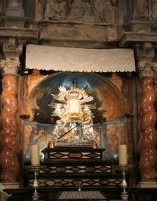 Imagen secundaria 2 - Arriba, la entrada a la cueva y la fachada de la antigua hospedería. Abajo a la izquierda, las escaleras que descienden al santuario. Abajo a la derecha, la imagen de la Virgen, flanqueada por columnas salomónicas. 