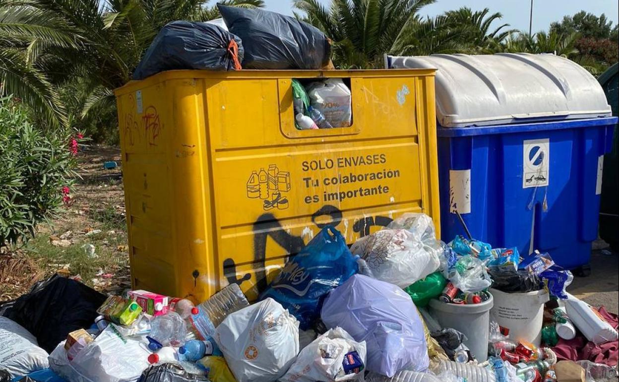 Contenedores repletos y rodeados de bolsas. 