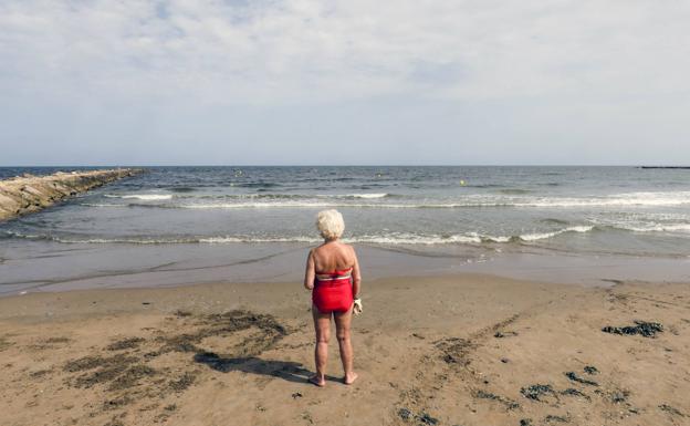 Galería. Una mujer contempla la playa desierta. 