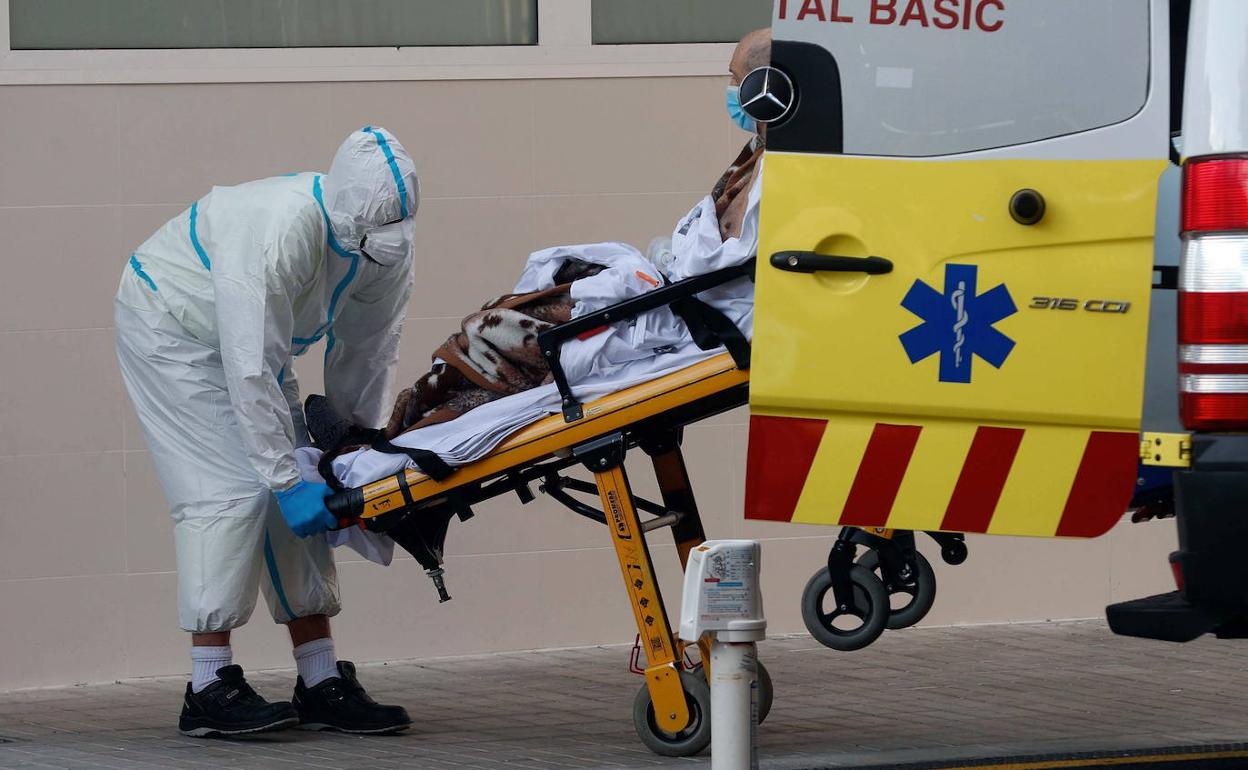 Un sanitario lleva al Clínico a un enfermo de Covid. 