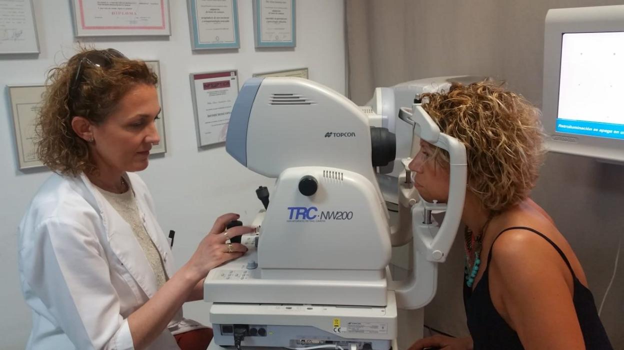 Una médico realiza pruebas oculares a su paciente. lp