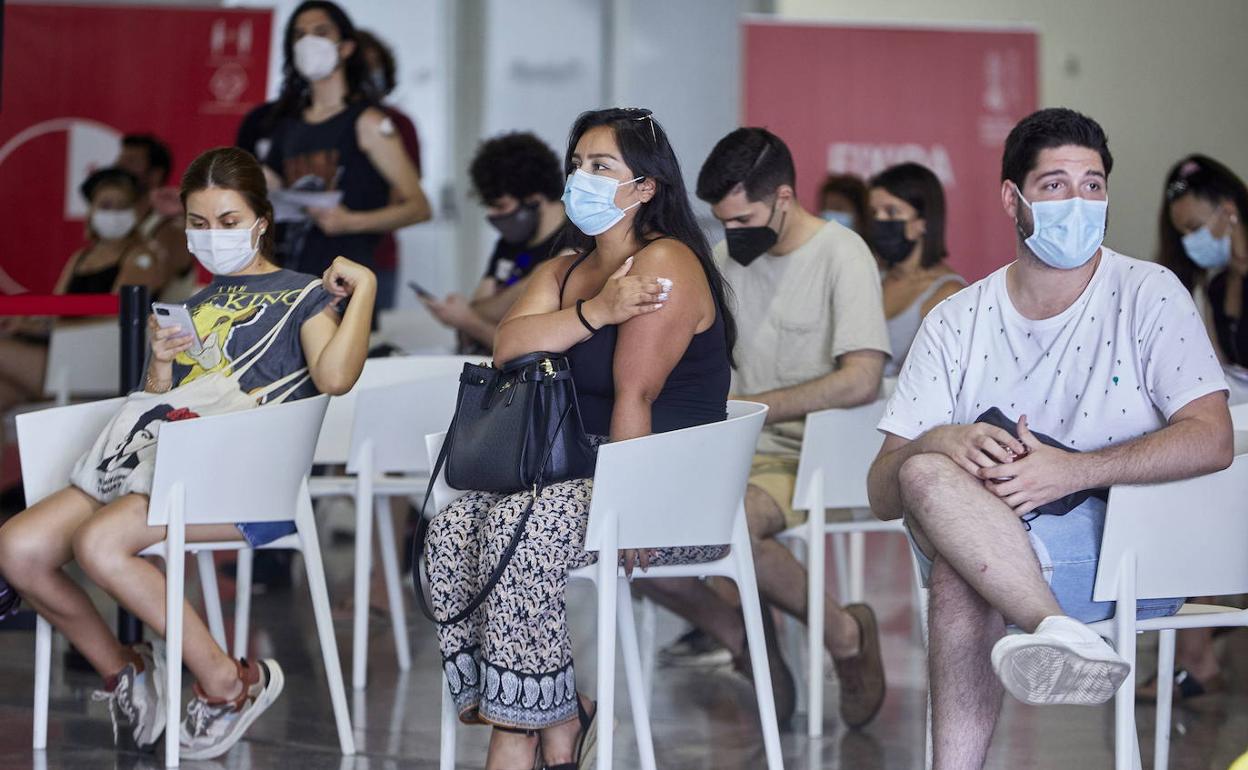 Jóvenes esperan tras la vacunación en el Príncipe Felipe. 