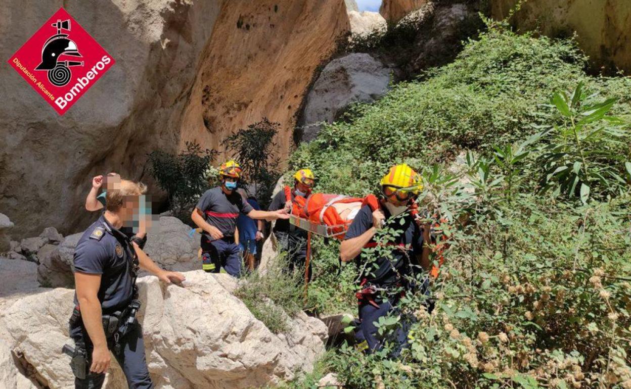 Los bomberos llevan en una camilla de rescate a la mujer herida. 