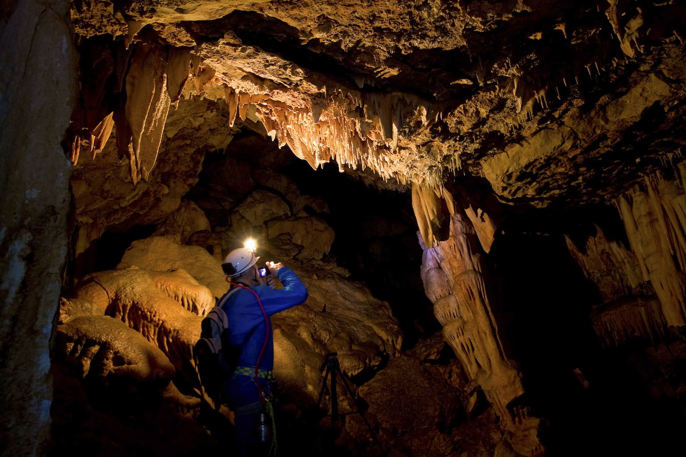 Espeleólogo en una cueva de estalactitas 