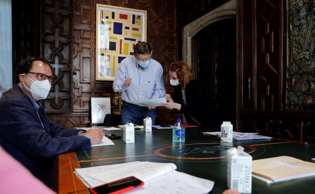 El conseller de Hacienda, Vicent Soler, junto a su directora general de Presupuesto, Eva Martínez, con el presidente Puig. 