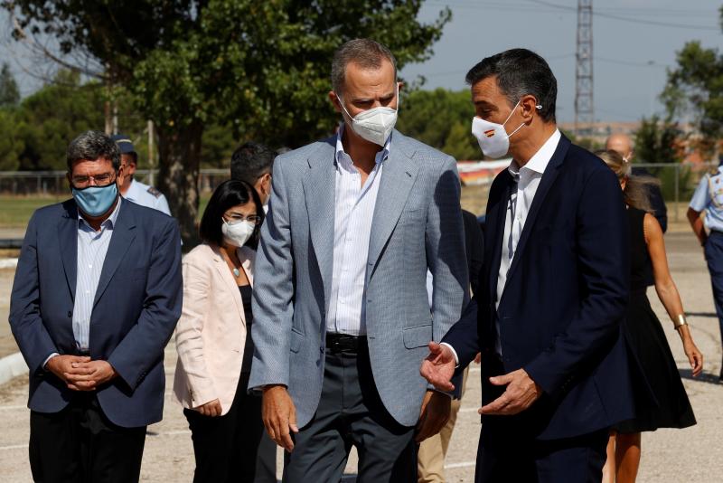 El rey Felipe VI y el presidente del Gobierno, Pedro Sánchez, conversan durante su visita este sábado al centro de acogida temporal instalado en la base de Torrejón.