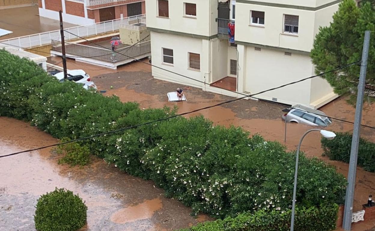 Un hombre, atrapado encima de un coche en Benicàssim esta mañana. 