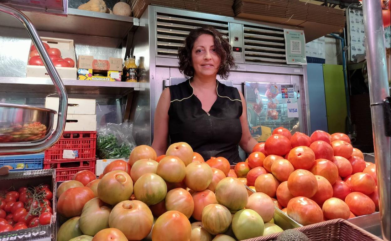 La verdulera Teresa Orts tras dos montones de tomates de su mostrador. 