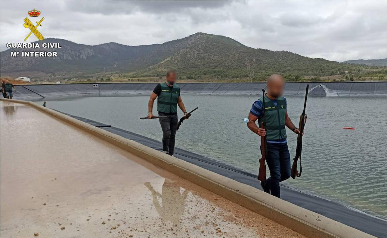 Dos guardias civiles con algunas armas recuperadas bajo el agua. 