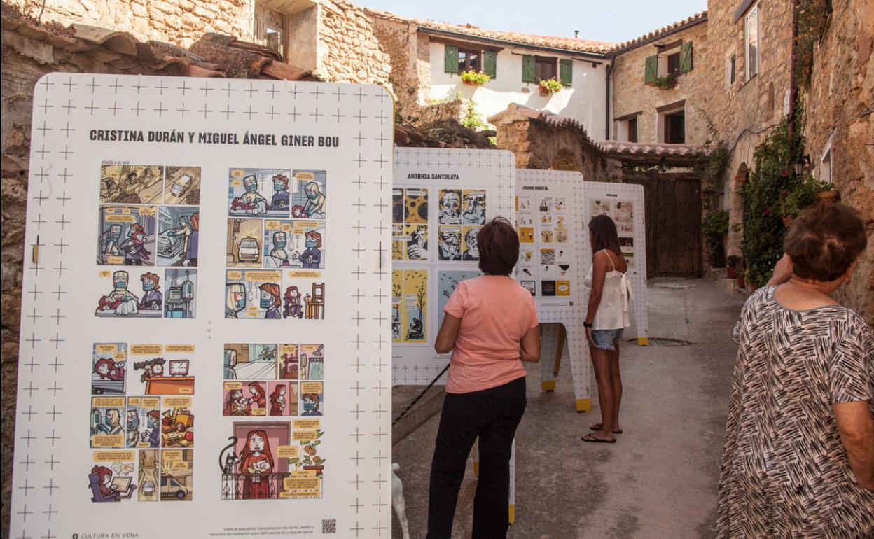 Vecinos de Parras de Martín (Teruel) contemplan algunas de las viñetas.