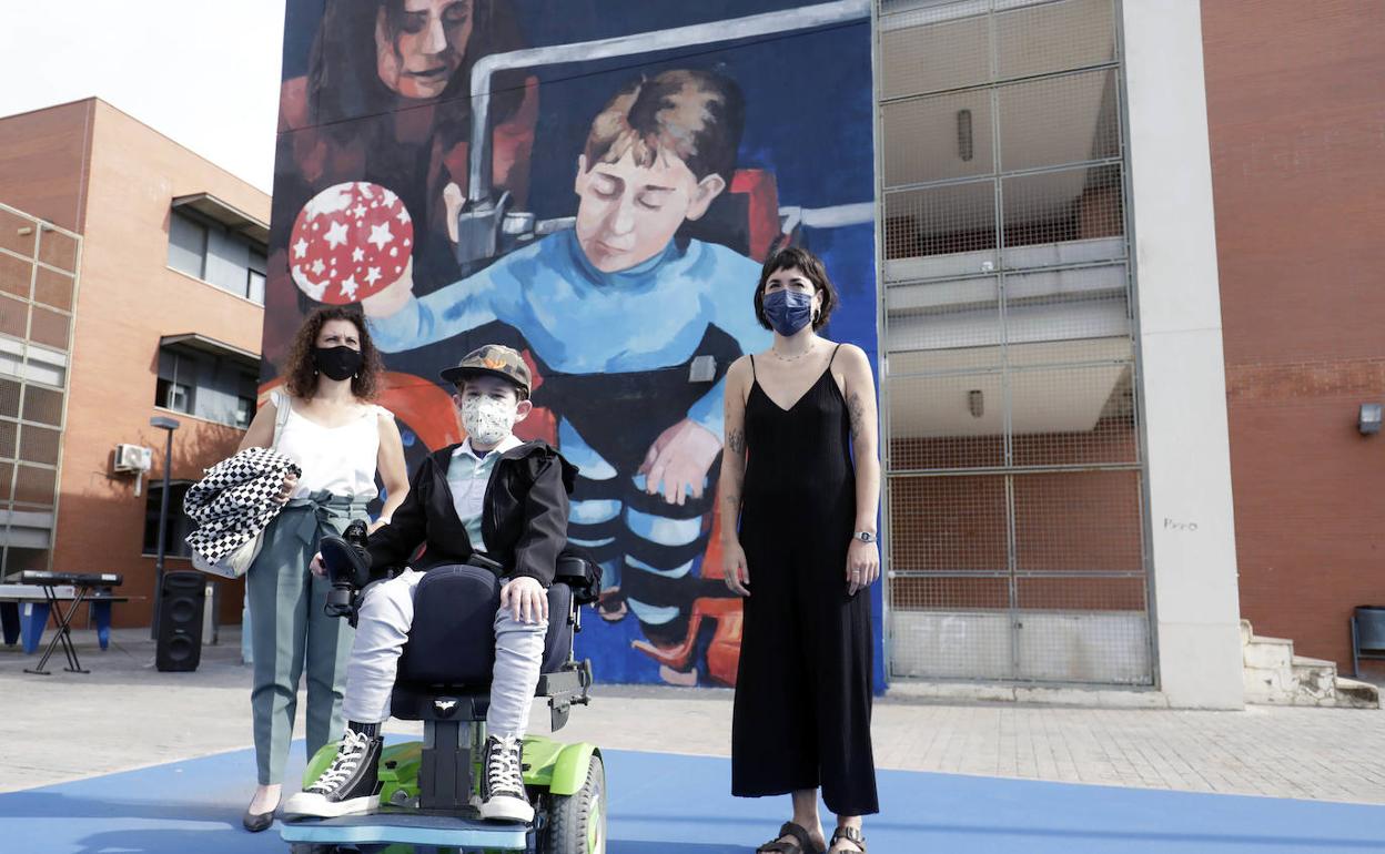 Elena García, Álvaro de la Calle y Sara Mono posan delante del mural. 