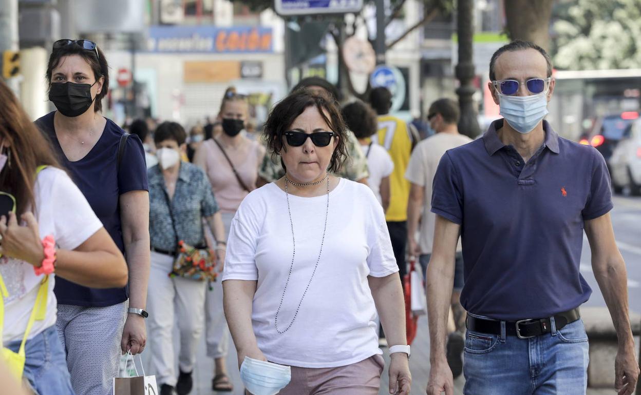 Gente en las calles de Valencia, unos con mascarilla y otros sin ella. 