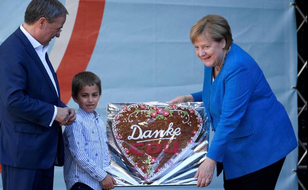 Merkel, con una tarta de agradecimiento de su partido.