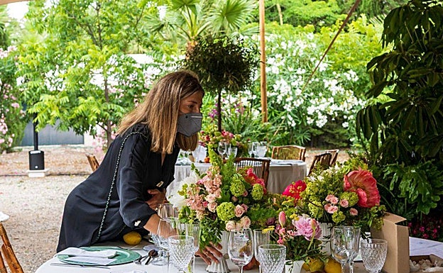 Lorena Oliver, de Araventum, dando los últimos retoques a la decoración floral de las mesas de una boda.