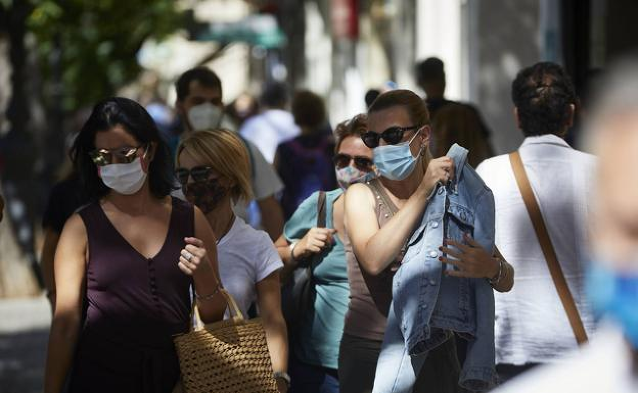 Un grupo de mujeres pasea por una calle céntrica de Valencia.