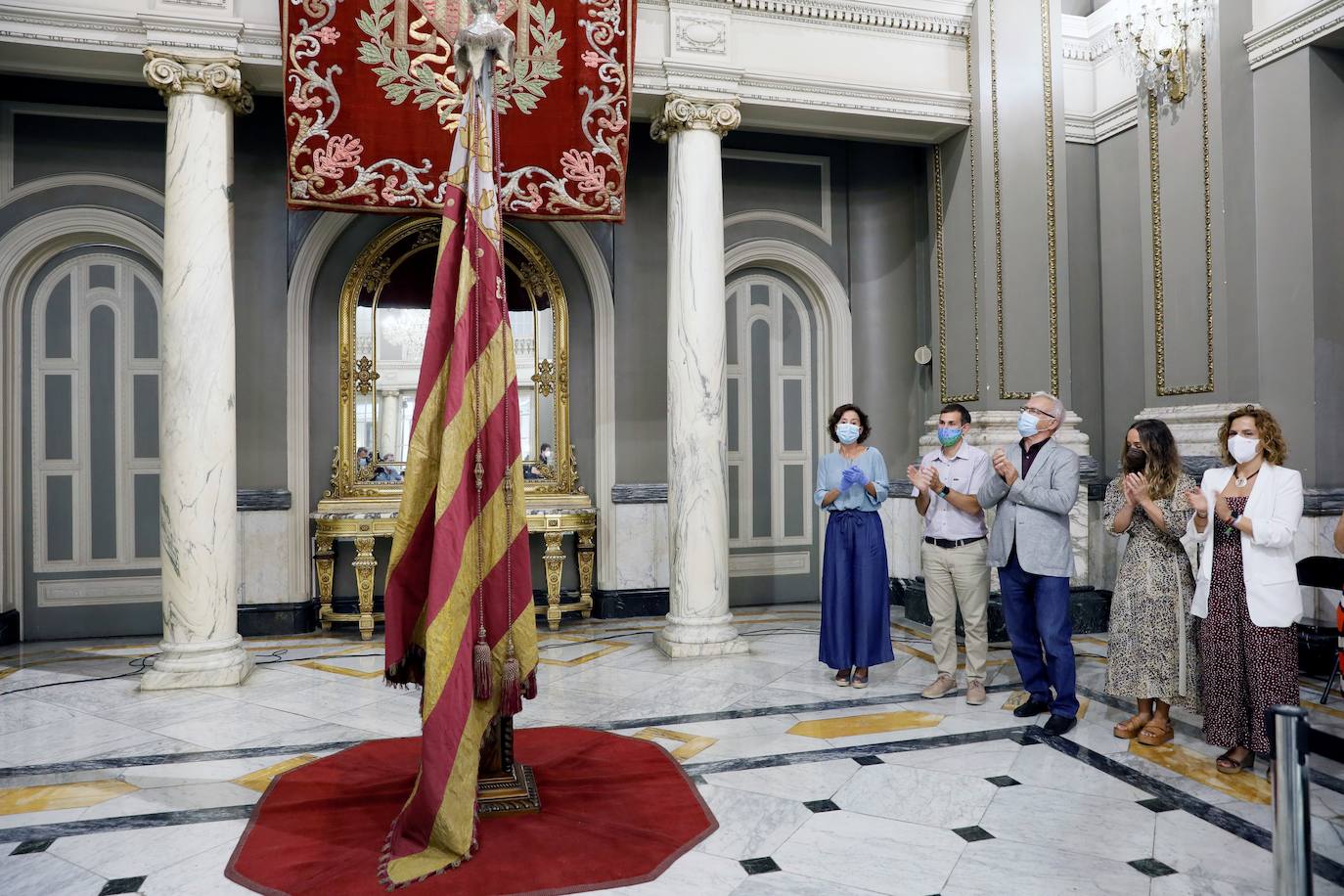 Cuatro meses de restauración devuelven el brillo a la enseña de 1928, que procesionará el 9 d'Octubre. Los expertos comprueban que el azul grisáceo que corona la pieza responde al mismo tono que muestra la bandera del siglo XVI