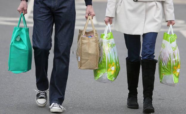 Dos personas con bolsas de la compra. 