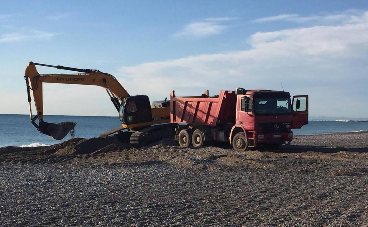 Retirada de material en la playa de Corinto, en el término de Sagunto, esta mañana. 