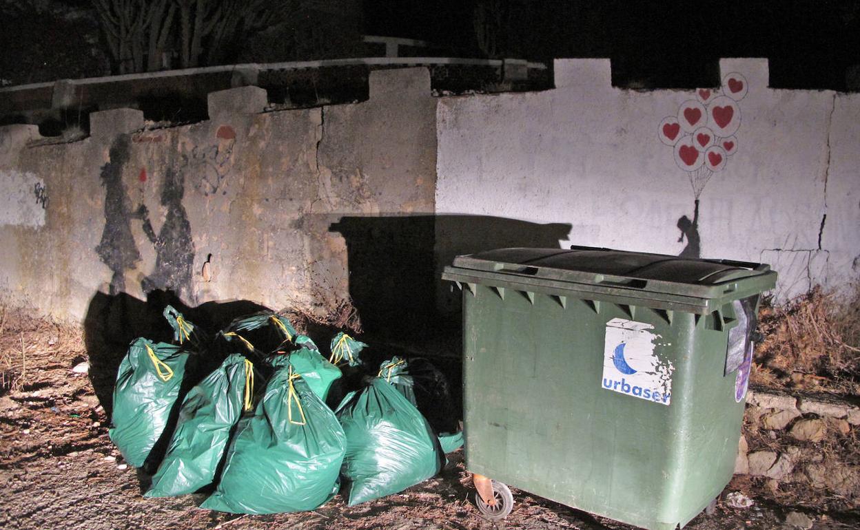 Bolsas de basura acumuladas junto a un contenedor de la zona de Les Rotes. 